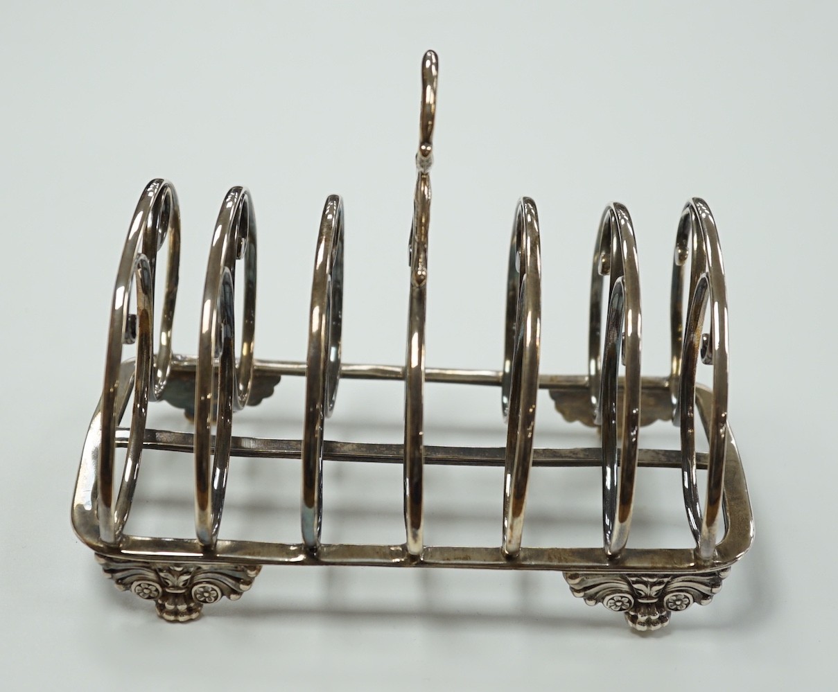 A William IV silver seven bar toastrack, with ring handle, on winged paw feet, Settle & Wilkinson, Sheffield, 1830, length 16.7cm, 10oz.
